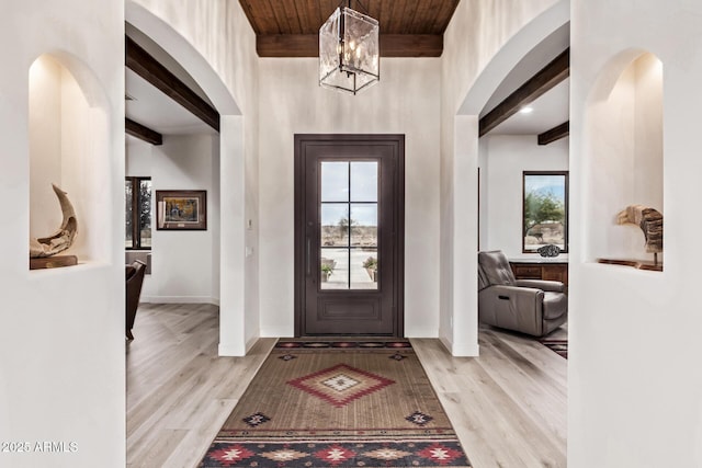 entryway featuring light hardwood / wood-style flooring, beamed ceiling, wood ceiling, and an inviting chandelier