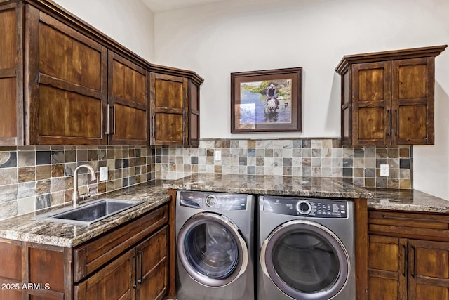 laundry area featuring cabinets, washer and clothes dryer, and sink