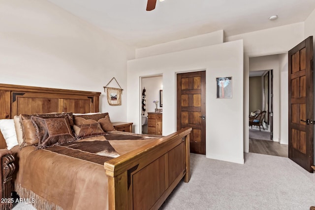 bedroom featuring ceiling fan, ensuite bathroom, and light carpet