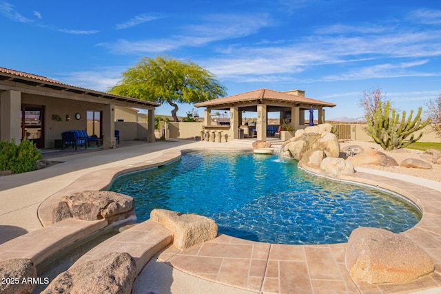 view of pool featuring pool water feature, a patio area, and a bar