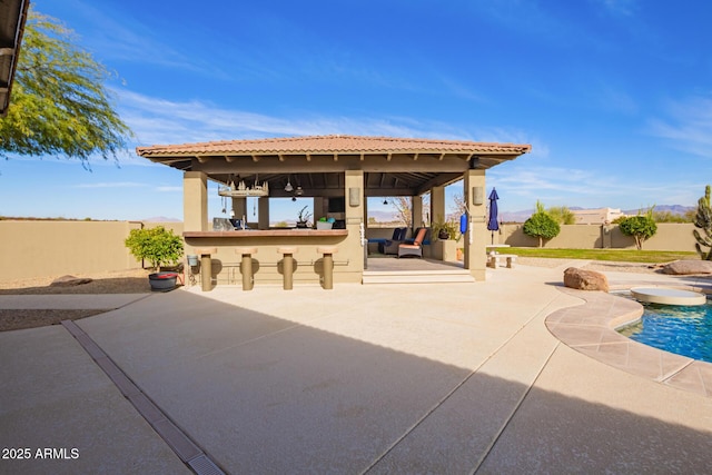 view of patio / terrace featuring a gazebo, exterior bar, and a fenced in pool