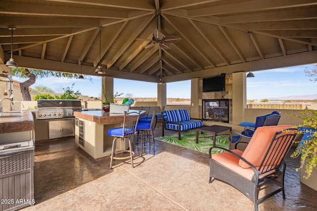 view of patio / terrace featuring an outdoor kitchen, an outdoor wet bar, an outdoor living space with a fireplace, a gazebo, and a grill