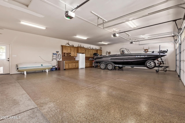 garage featuring white refrigerator and a garage door opener