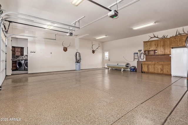 garage with separate washer and dryer, a garage door opener, and white fridge