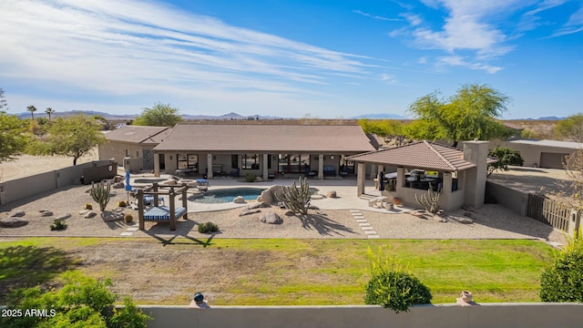 back of house with a mountain view, a fenced in pool, a gazebo, a yard, and a patio area