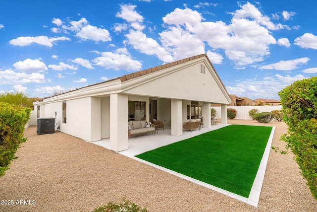 rear view of property with a fenced backyard, a yard, outdoor lounge area, central AC unit, and a patio area