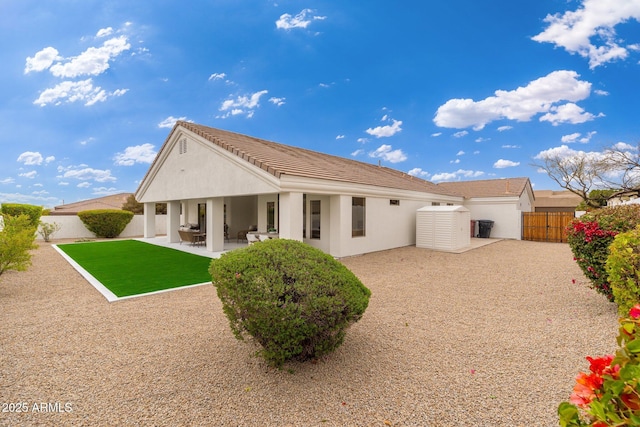 back of house with a patio area, a fenced backyard, and stucco siding