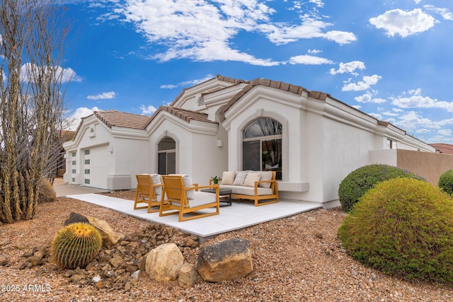 rear view of property featuring a garage, an outdoor hangout area, stucco siding, and a tiled roof