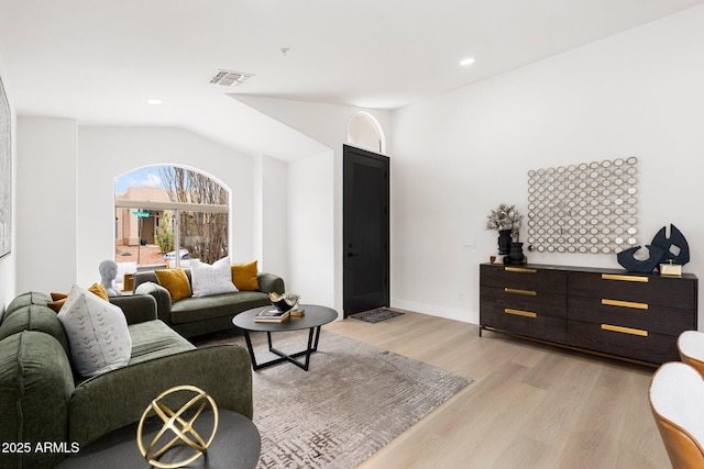 living area featuring visible vents, baseboards, recessed lighting, vaulted ceiling, and light wood-style floors