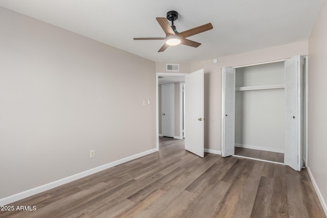 unfurnished bedroom featuring ceiling fan, hardwood / wood-style floors, and a closet