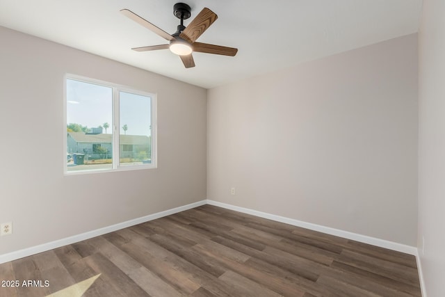 empty room with ceiling fan and dark hardwood / wood-style flooring