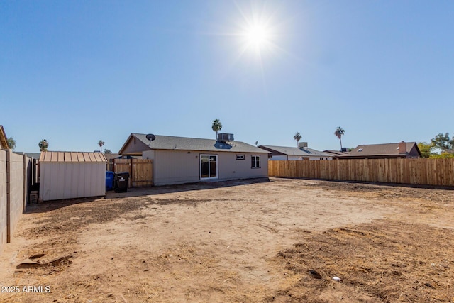 rear view of house featuring a storage shed