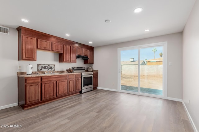 kitchen with stainless steel electric range oven, light hardwood / wood-style flooring, and sink