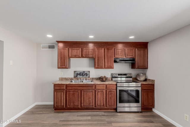 kitchen featuring stainless steel range with electric stovetop, hardwood / wood-style flooring, and sink