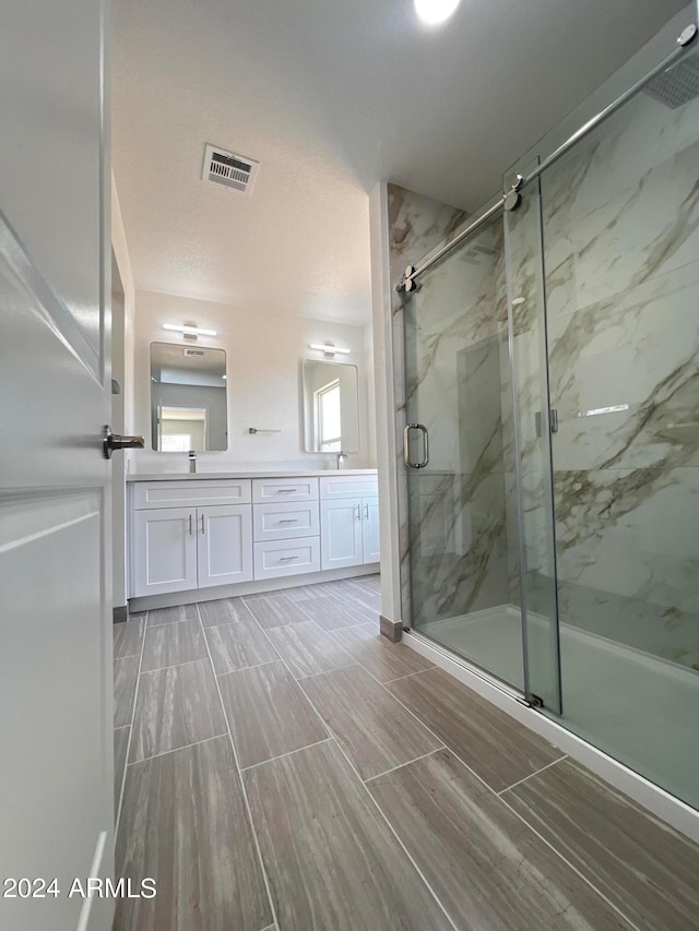 bathroom with vanity and a shower with shower door