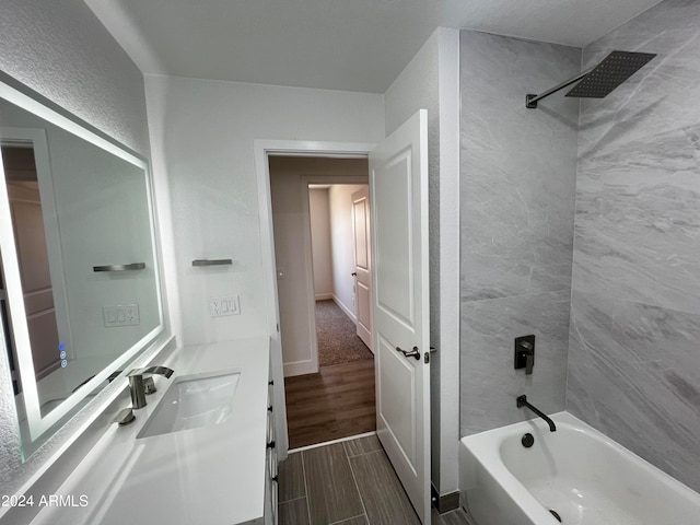 bathroom featuring tiled shower / bath and vanity