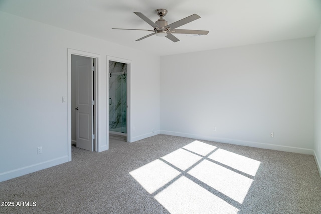 unfurnished bedroom with carpet flooring, a spacious closet, ensuite bath, a closet, and ceiling fan