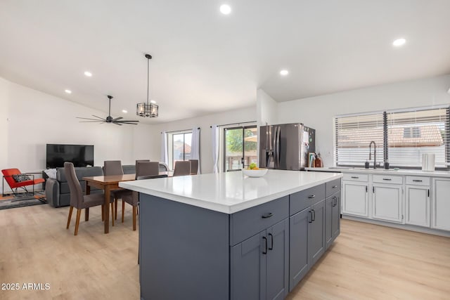 13918 N 78th Ave, Peoria, AZ 85381 - kitchen with stainless steel fridge, light wood-type flooring, a sink, light countertops, and a kitchen island