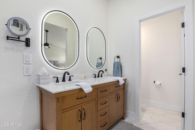13918 N 78th Ave, Peoria, AZ 85381 - full bath with double vanity, marble look tiles, ceiling fan, baseboards, and toilet