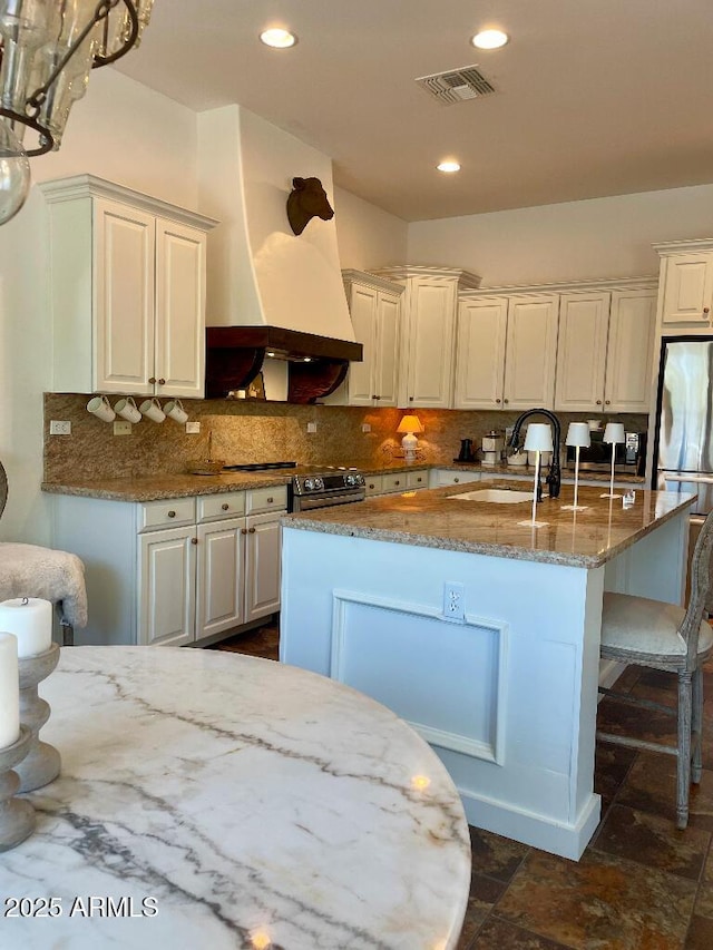 20502 W Ridge Rd, Buckeye, AZ 85396 - kitchen featuring stainless steel appliances, tasteful backsplash, light stone countertops, a kitchen island with sink, and recessed lighting
