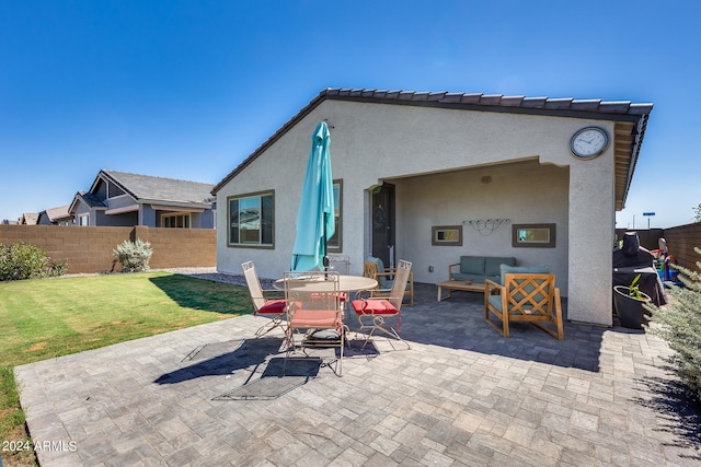 back of property with a lawn, outdoor lounge area, and a patio area