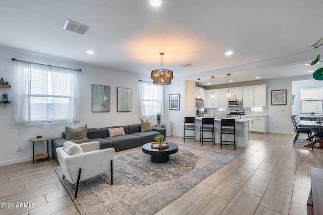 living room featuring an inviting chandelier and light hardwood / wood-style floors