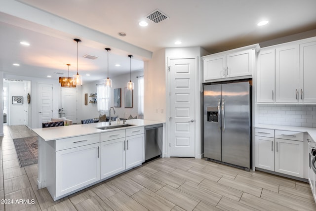 kitchen with stainless steel appliances, white cabinetry, kitchen peninsula, and sink