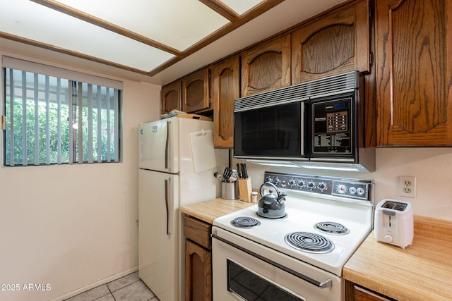 3131 W Cochise Dr Unit 144, Phoenix, AZ 85051 - kitchen featuring white appliances, light countertops, light tile patterned floors, and brown cabinetry