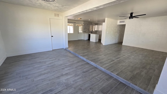 unfurnished living room with ceiling fan and dark hardwood / wood-style floors