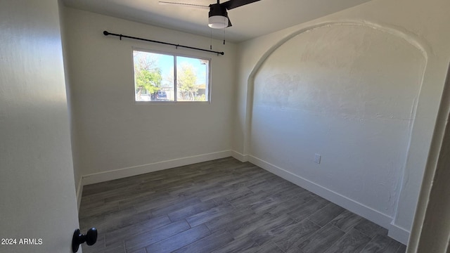 empty room with ceiling fan and dark hardwood / wood-style flooring