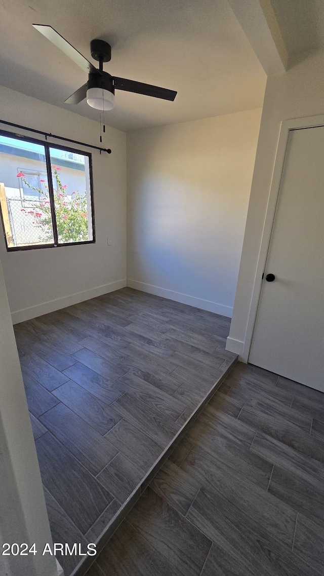 spare room with ceiling fan and dark hardwood / wood-style flooring