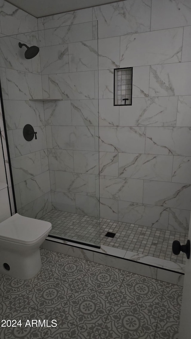 bathroom featuring tiled shower and toilet