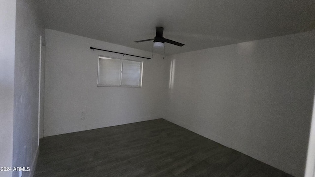 empty room with ceiling fan and dark hardwood / wood-style flooring