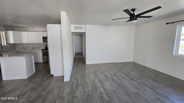 kitchen featuring white cabinetry, appliances with stainless steel finishes, decorative backsplash, and hardwood / wood-style floors