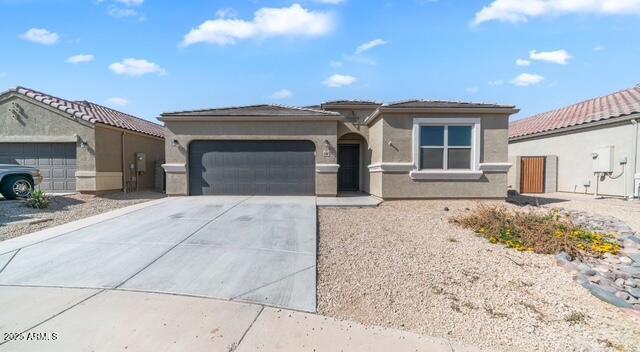 view of front of home with driveway, stucco siding, and an attached garage