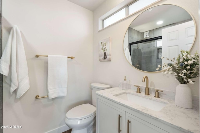 bathroom featuring vanity, toilet, and a shower with shower door