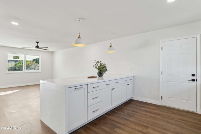 kitchen featuring decorative light fixtures, dark hardwood / wood-style floors, kitchen peninsula, ceiling fan, and white cabinets