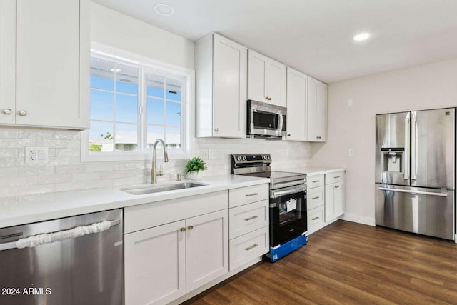 kitchen featuring dark wood-type flooring, sink, white cabinetry, stainless steel appliances, and backsplash