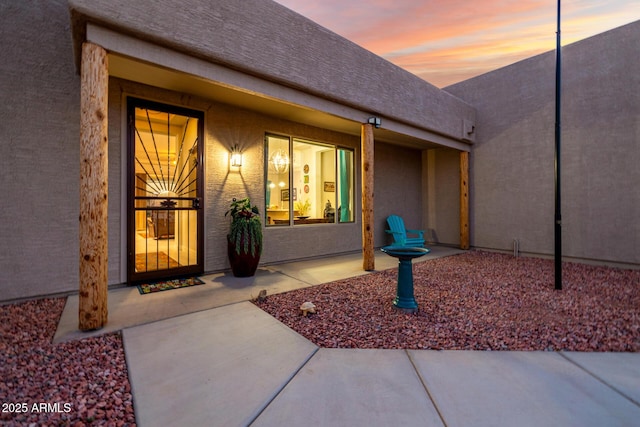 doorway to property featuring a patio and stucco siding