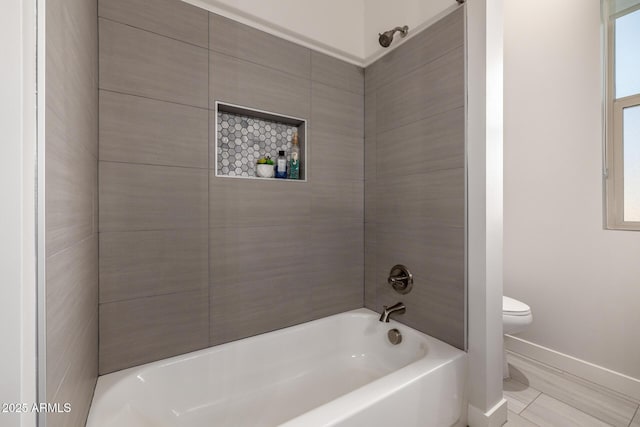 bathroom featuring bathtub / shower combination, baseboards, and toilet