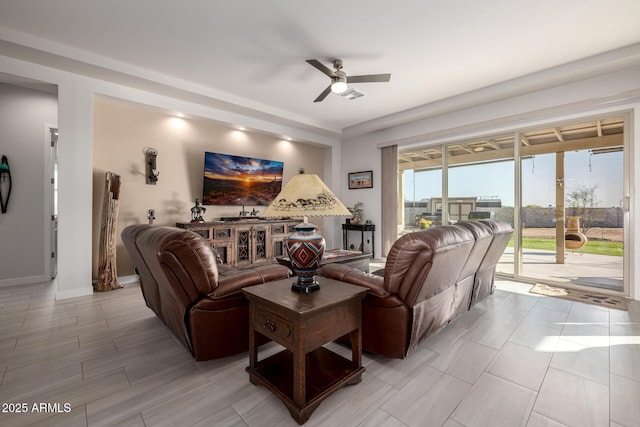 living area with ceiling fan and baseboards