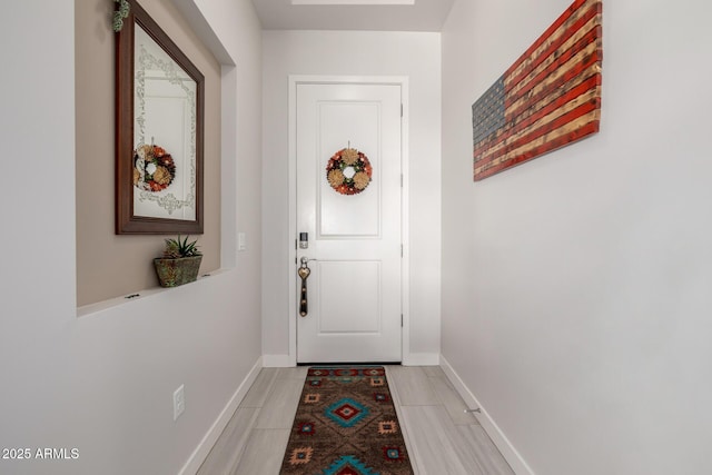 doorway to outside featuring light tile patterned floors and baseboards
