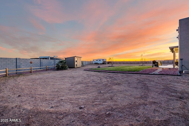 view of yard featuring an outdoor structure, fence, and a storage unit