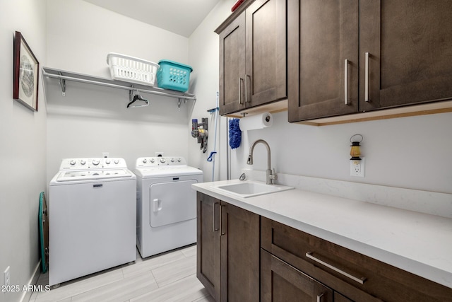 washroom with a sink, cabinet space, and washing machine and dryer