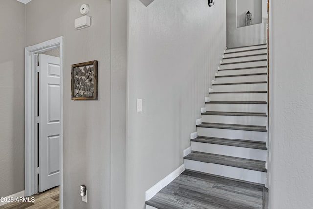 staircase with baseboards and wood finished floors
