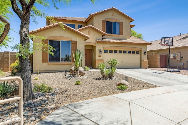 view of front of home featuring a tile roof, a garage, concrete driveway, stucco siding, and fence