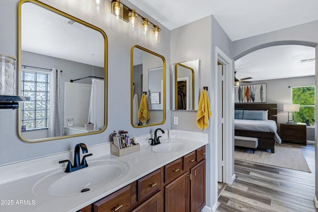 bathroom with wood finished floors, visible vents, a ceiling fan, and a sink