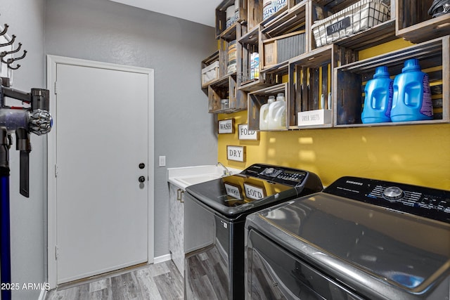 laundry area with wood finished floors, washer and clothes dryer, and laundry area