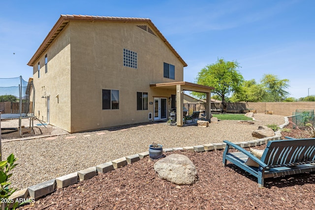 back of house with stucco siding, a patio, and a fenced backyard