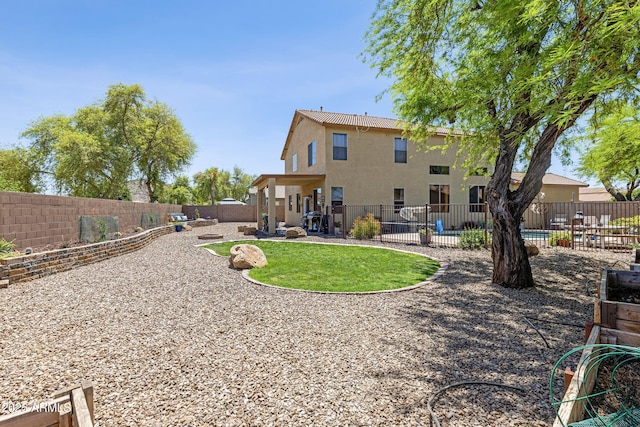 back of house with a fenced backyard, stucco siding, and a patio area